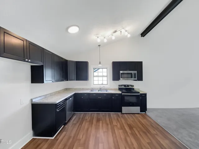 a kitchen with granite countertop a sink stove and refrigerator