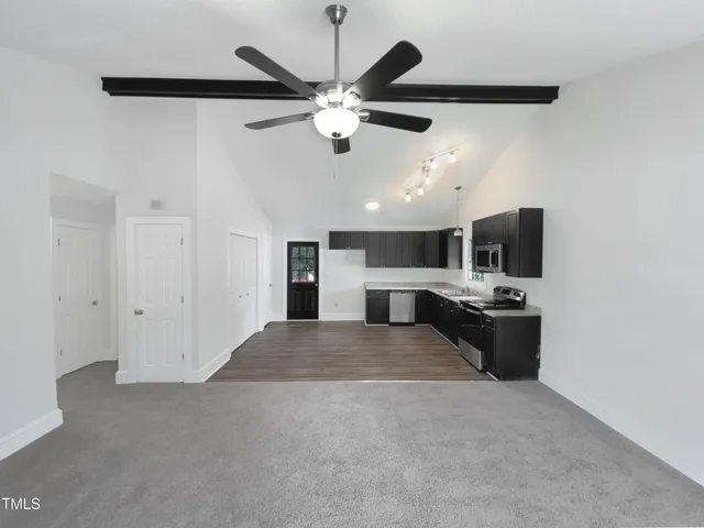 a view of a livingroom with a stove and a ceiling fan