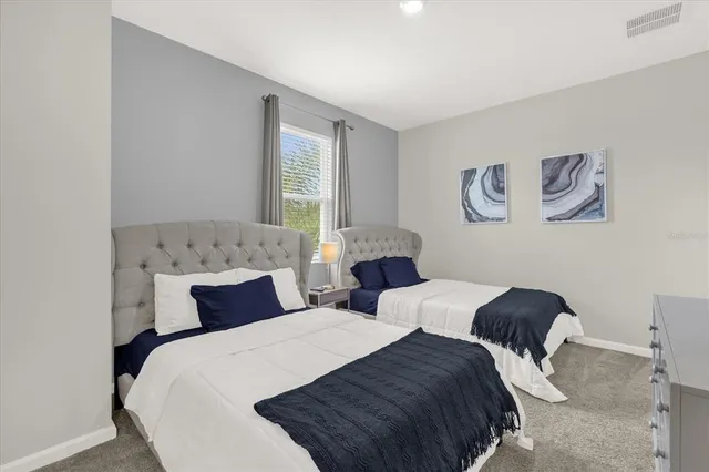 a bedroom with two beds and painting on the wall