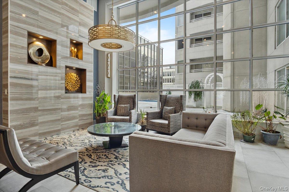 100 Cutter Mill Road, Unit 3E Great Neck, NY 11021 - Photo 3 of 14 a view of a patio with couches chairs and potted plants