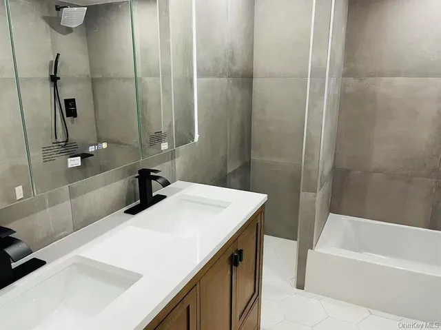 a bathroom with a tub sink and mirror