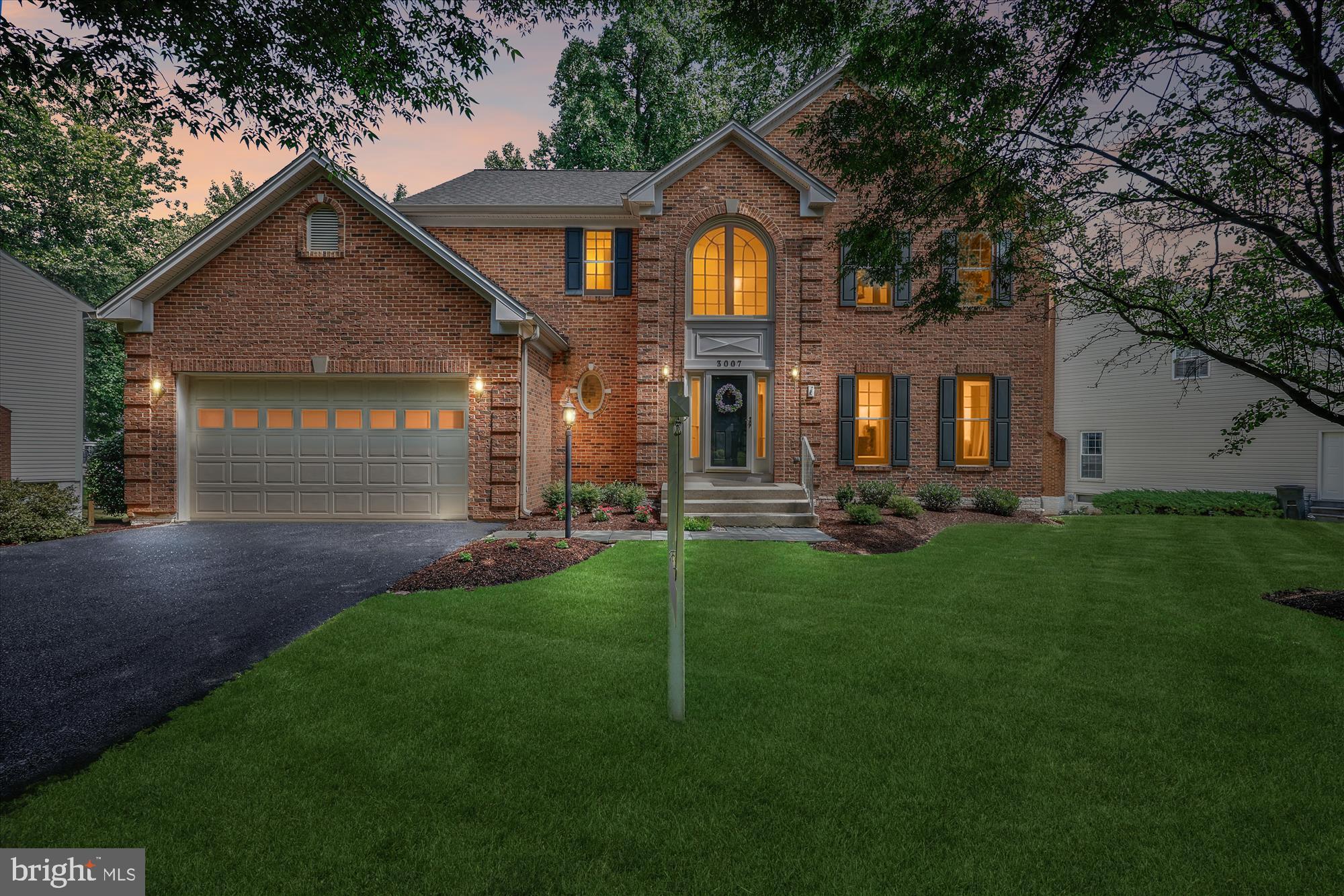 a front view of a house with a yard and trees