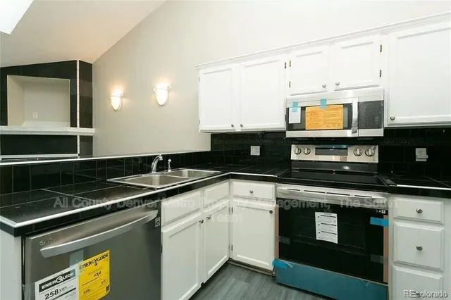 a kitchen with stainless steel appliances granite countertop a sink a stove and microwave