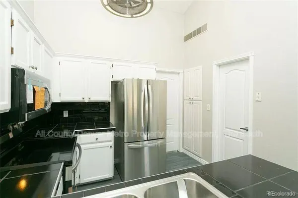 a kitchen with a refrigerator and a stove top oven