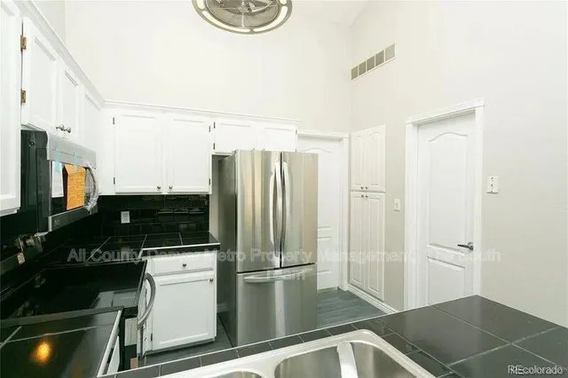a kitchen with a refrigerator and a stove top oven