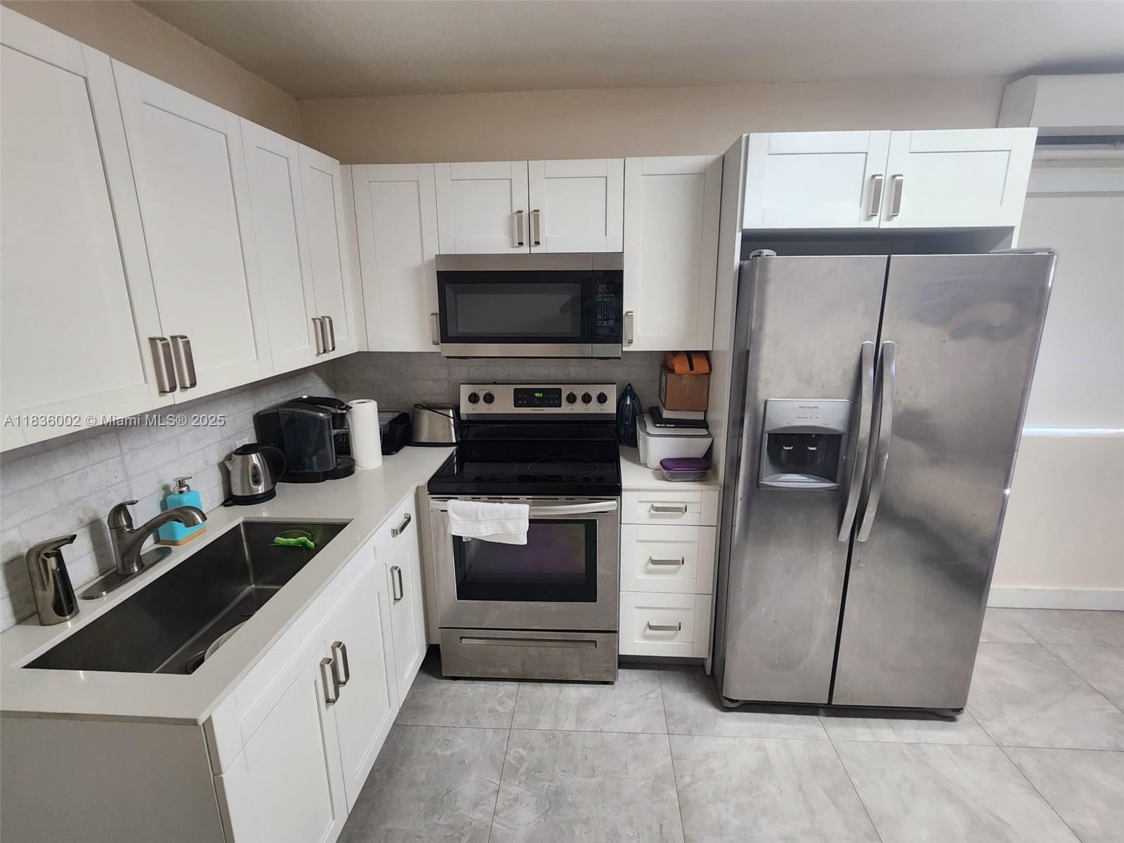 2165 Southwest 47th Street, Unit 2 Dania Beach, FL 33312 - Photo 3 of 10 a kitchen with a refrigerator sink and cabinets