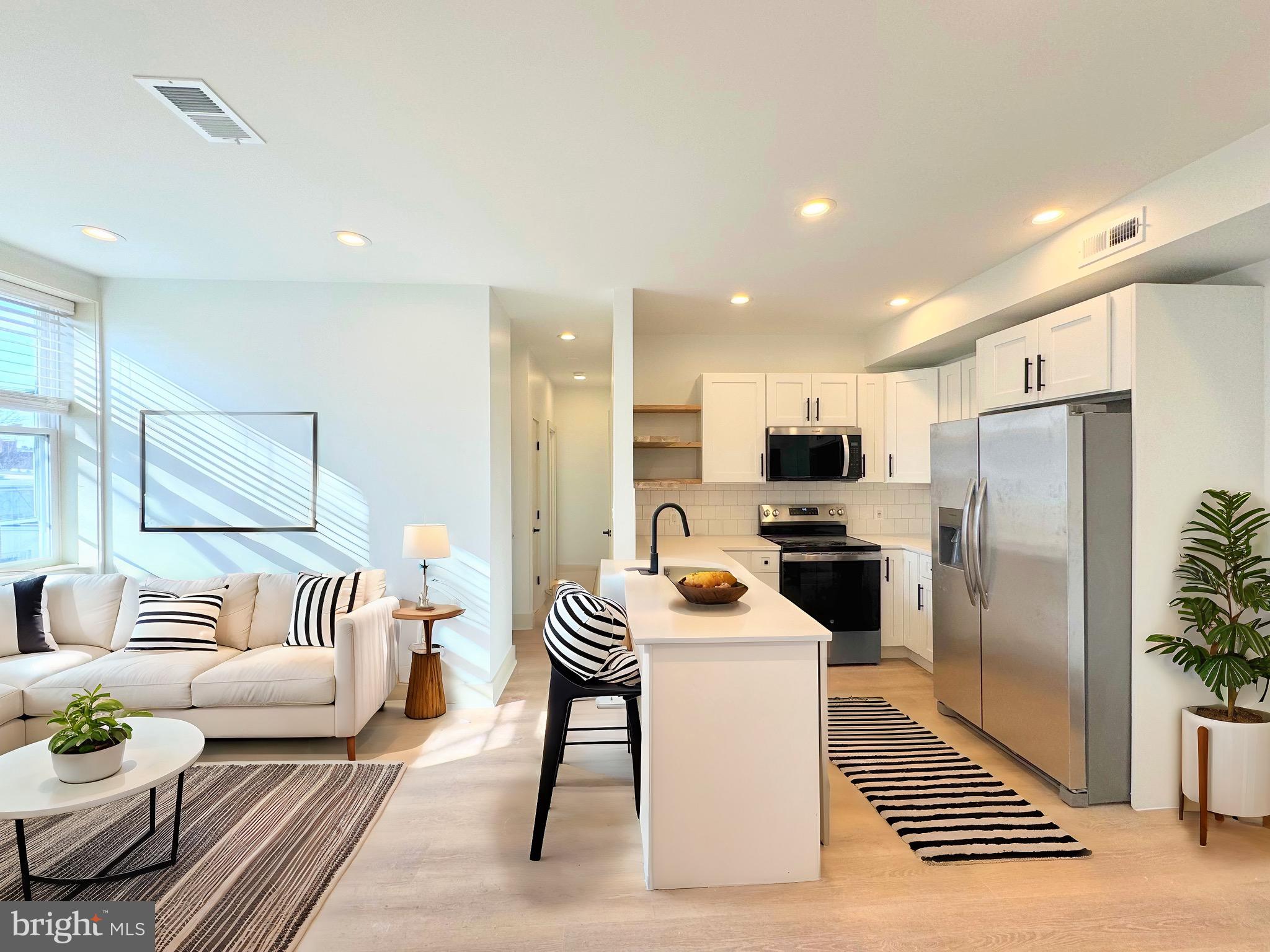 a kitchen with stainless steel appliances a refrigerator and a couch