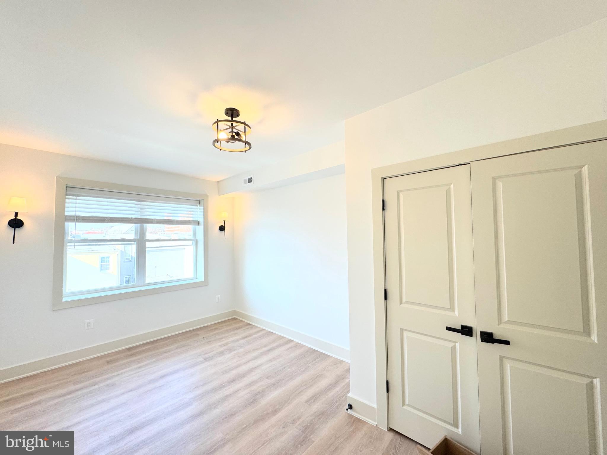 1802 11th Street Northwest, Unit 3B Washington, DC 20001 - Photo 12 of 19 an empty room with wooden floor ceiling fan and windows