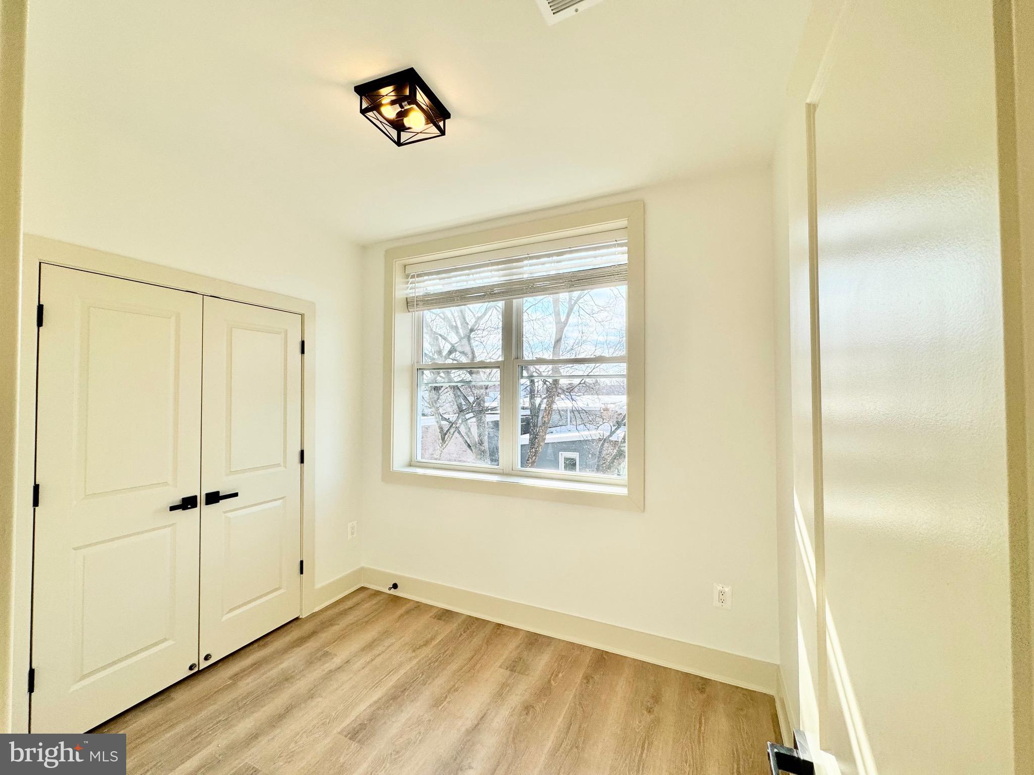 1802 11th Street Northwest, Unit 3B Washington, DC 20001 - Photo 14 of 19 a view of an empty room with wooden floor and a window