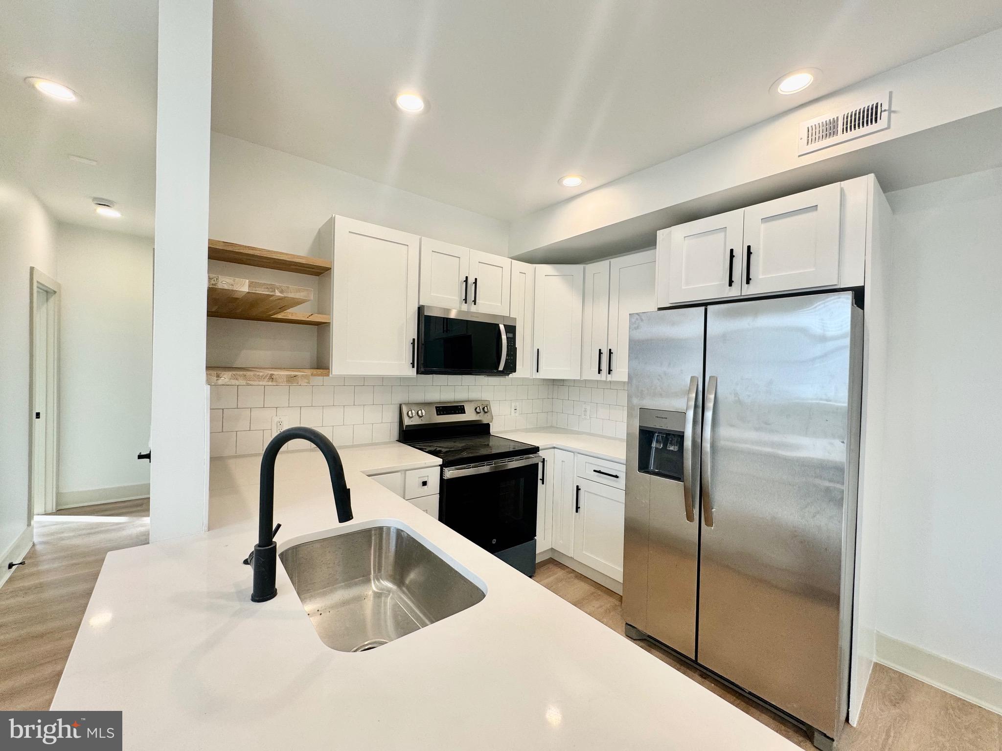 1802 11th Street Northwest, Unit 3B Washington, DC 20001 - Photo 3 of 19 a kitchen with granite countertop a refrigerator and a sink