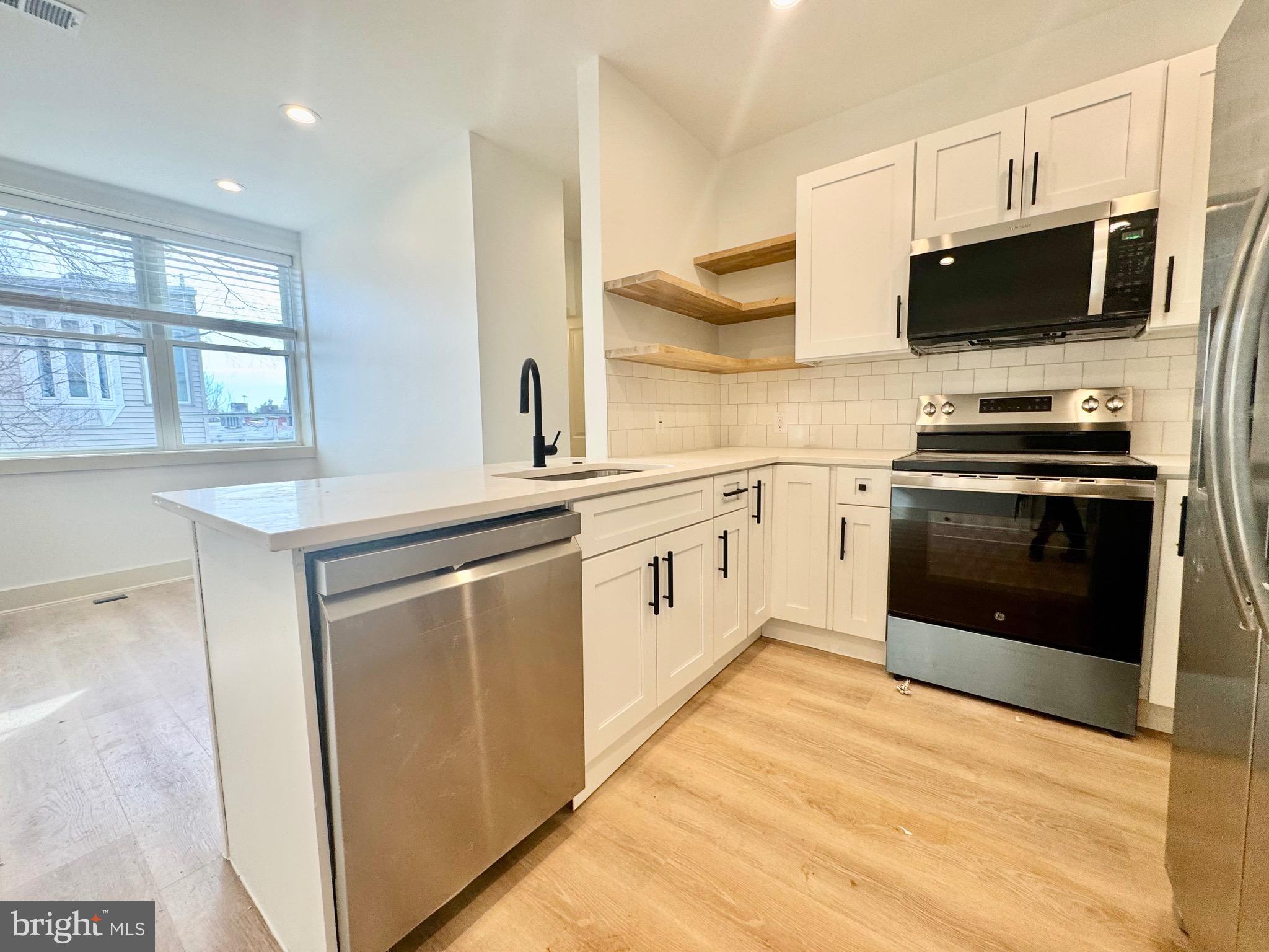 1802 11th Street Northwest, Unit 3B Washington, DC 20001 - Photo 6 of 19 a kitchen with stainless steel appliances granite countertop a stove a sink and a microwave