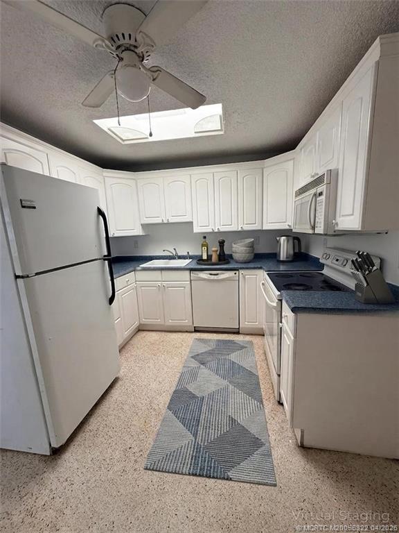 33 Southeast Sailfish Lane Stuart, FL 34996 - Photo 3 of 18 a kitchen with stainless steel appliances granite countertop a stove a sink a refrigerator and white cabinets