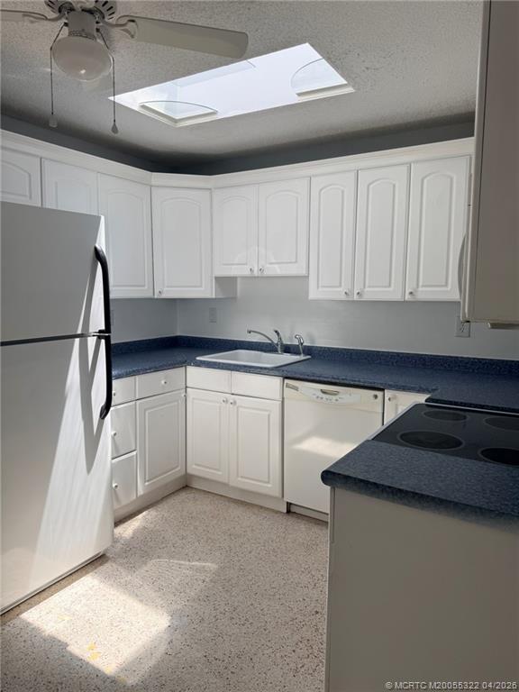 33 Southeast Sailfish Lane Stuart, FL 34996 - Photo 4 of 18 a kitchen with white cabinets and white appliances