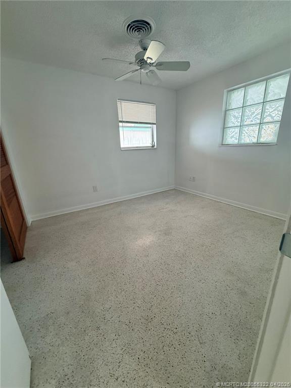 33 Southeast Sailfish Lane Stuart, FL 34996 - Photo 8 of 18 an empty room with windows and fan