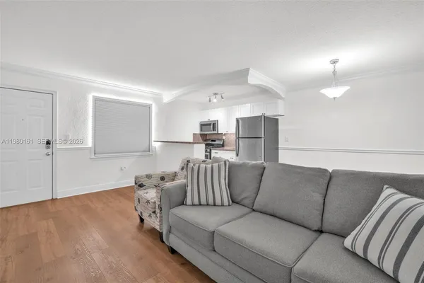 a living room with furniture and kitchen view