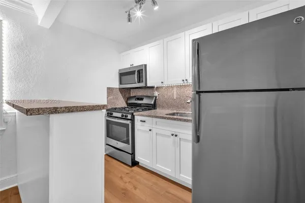 a kitchen with stainless steel appliances a refrigerator sink and stove
