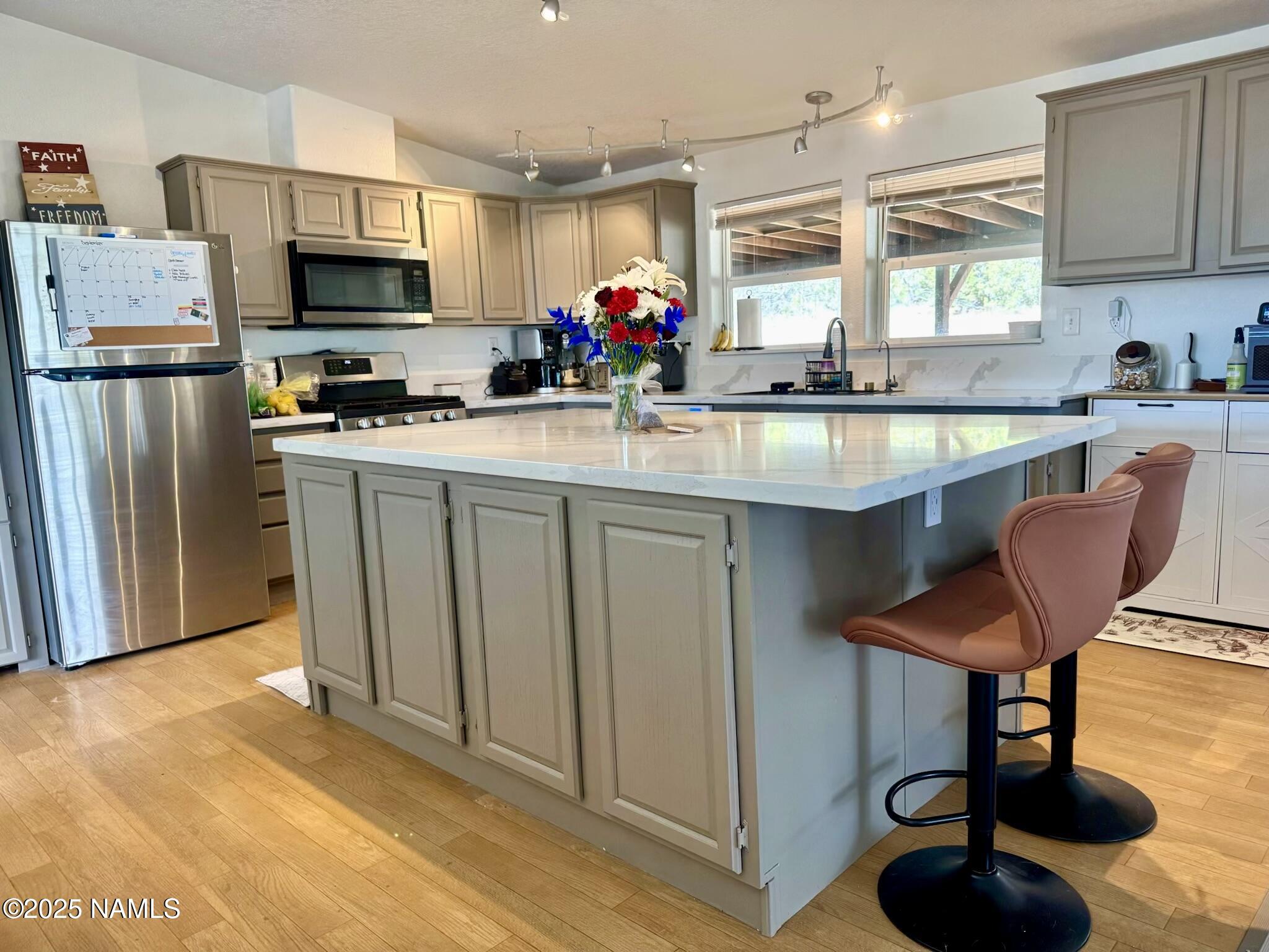 6083 North Joshua Tree Road Williams, AZ 86046 - Photo 3 of 40 a kitchen with stainless steel appliances dining table a sink and a refrigerator