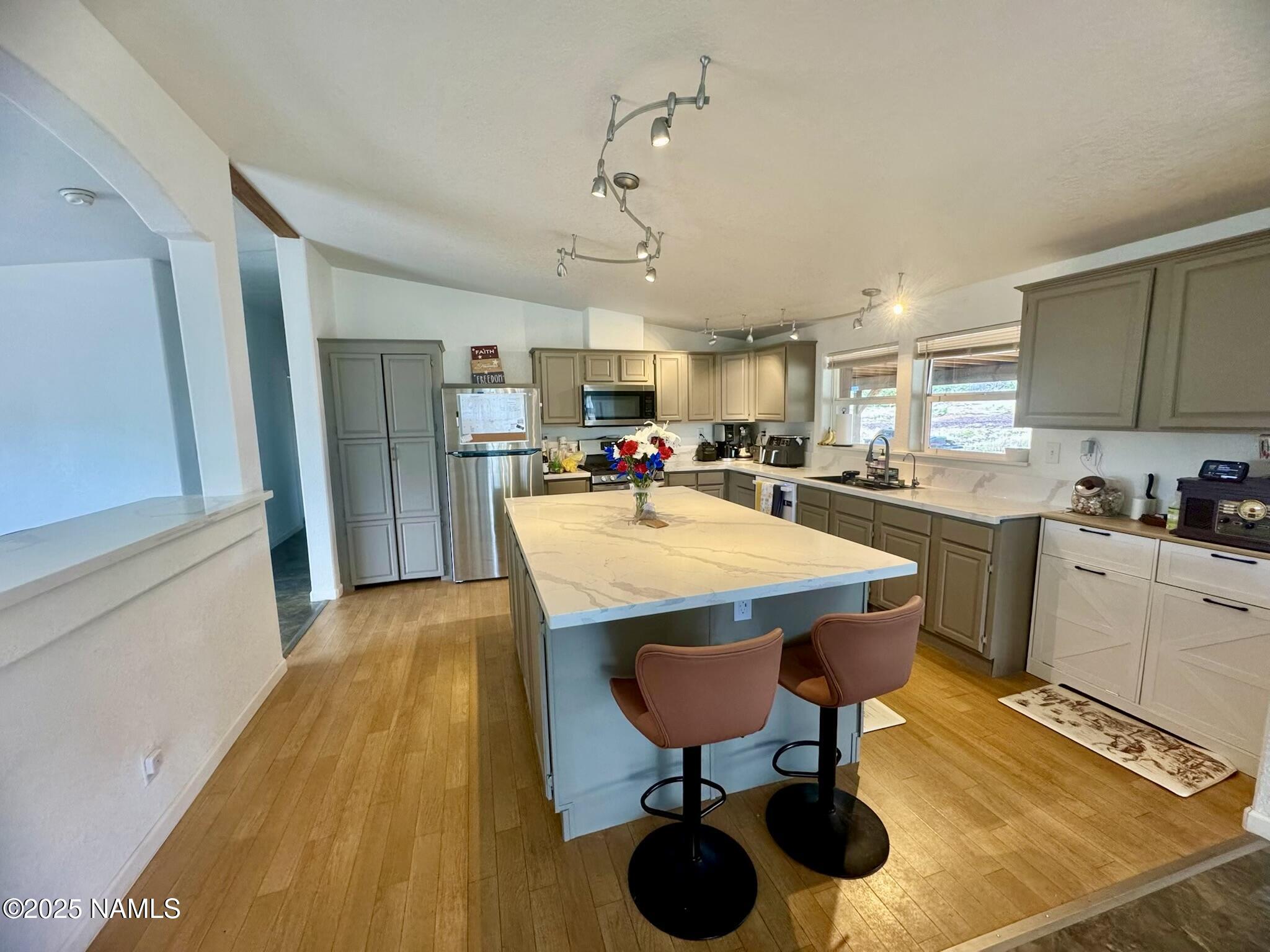 6083 North Joshua Tree Road Williams, AZ 86046 - Photo 4 of 40 a open kitchen with stainless steel appliances granite countertop a sink dishwasher and a refrigerator with wooden cabinets