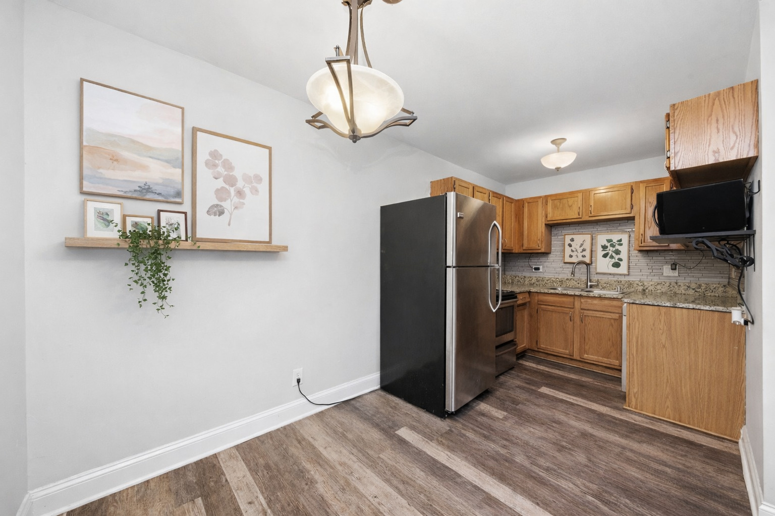 2300 Light Road, Unit 209 Oswego, IL 60543 - Photo 5 of 11 a kitchen with granite countertop a refrigerator stove and microwave