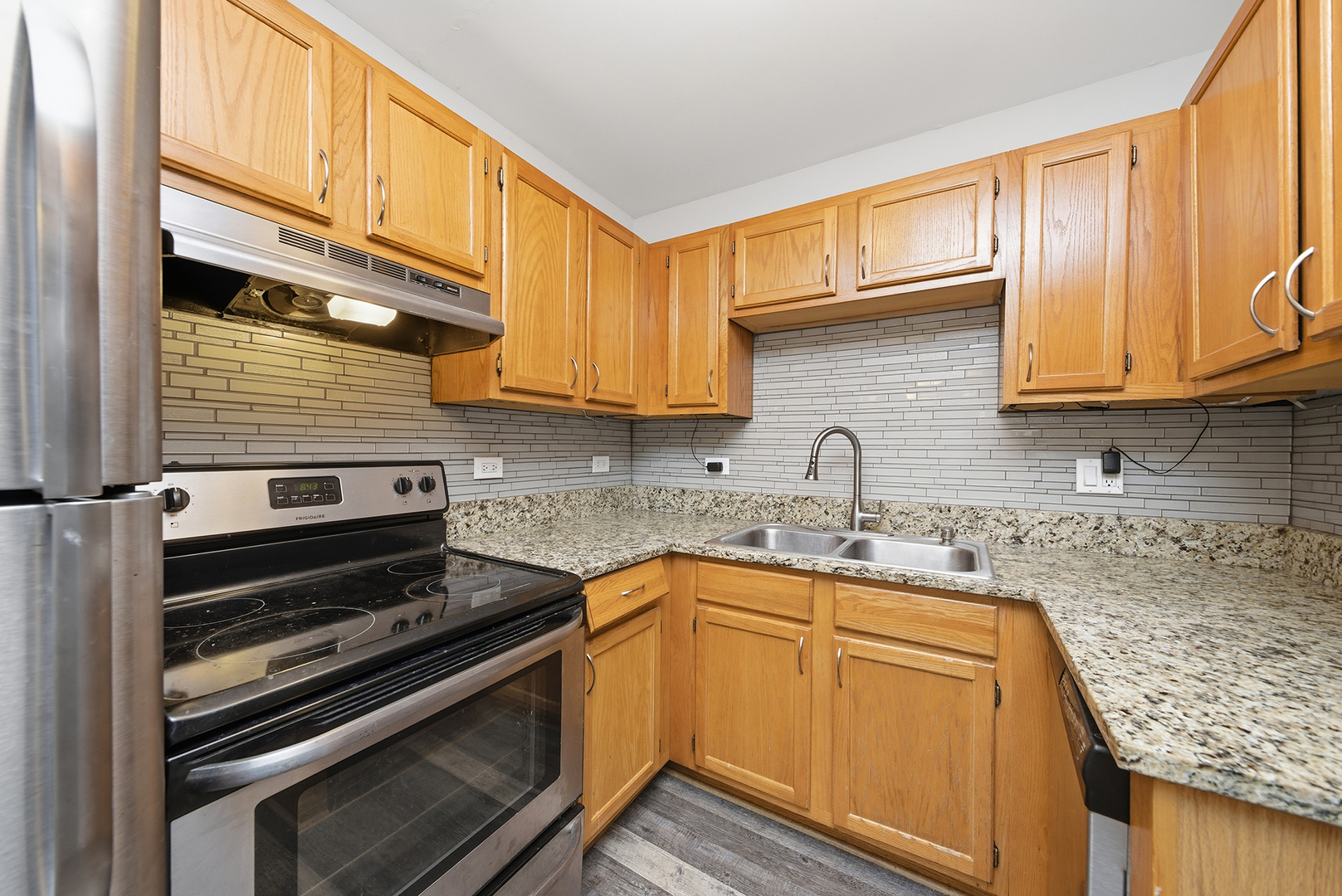 2300 Light Road, Unit 209 Oswego, IL 60543 - Photo 7 of 11 a kitchen with granite countertop a stove sink and cabinets