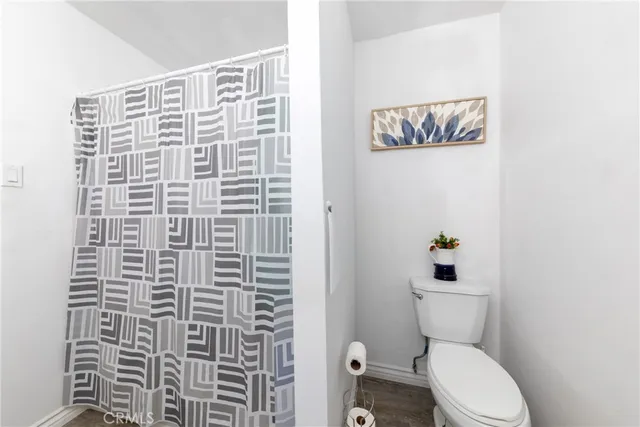 a bathroom with a toilet and a shower curtain