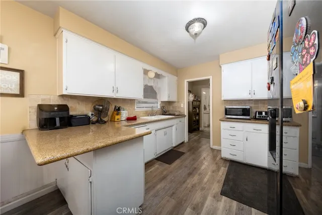 a kitchen with granite countertop white cabinets and white appliances