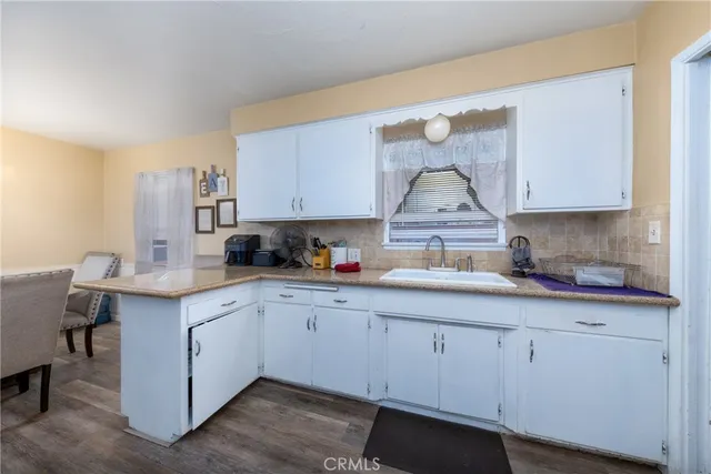 a kitchen with white cabinets and sink