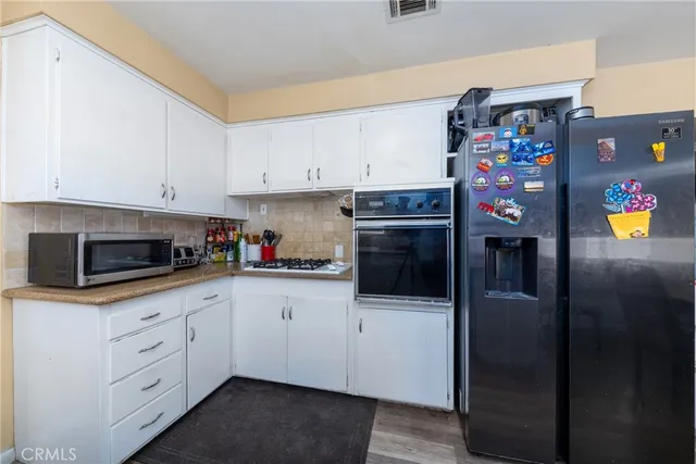 a kitchen with stainless steel appliances granite countertop a refrigerator and a stove top oven