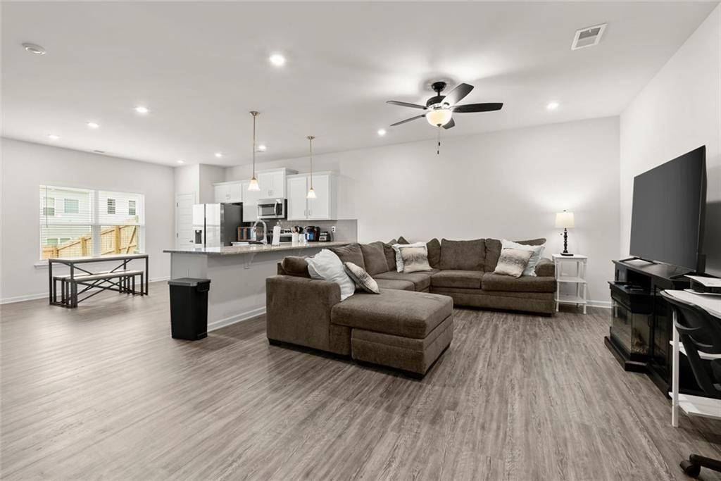 a living room with furniture and a flat screen tv with kitchen view