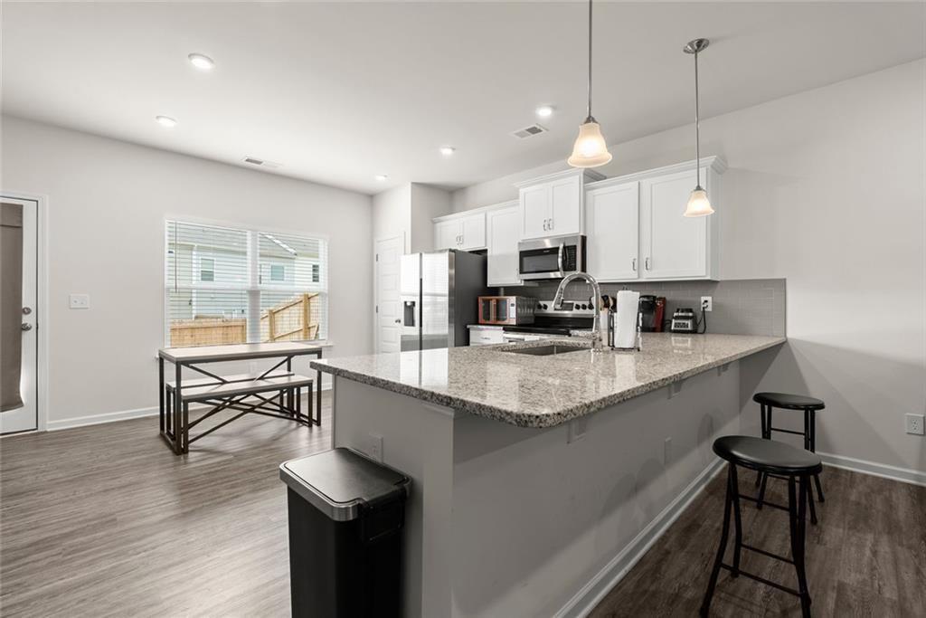 254 Pinnacle Way Jasper, GA 30143 - Photo 16 of 33 a kitchen with kitchen island granite countertop a sink a counter space appliances and a window