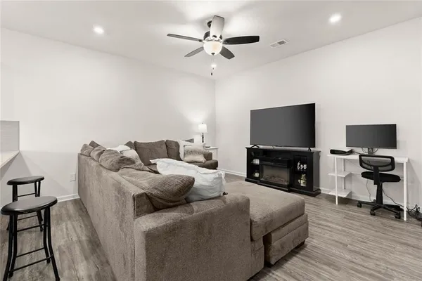 a living room with furniture and a flat screen tv with wooden floor