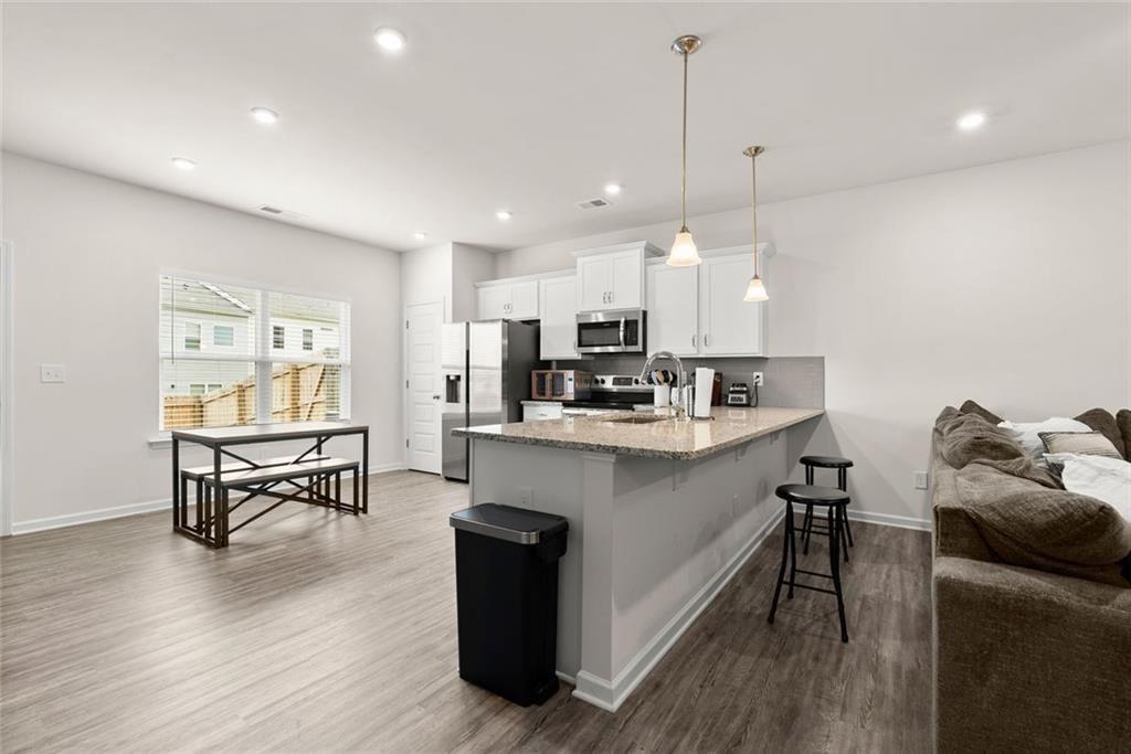 254 Pinnacle Way Jasper, GA 30143 - Photo 6 of 33 a kitchen with kitchen island a white counter top space a stove a refrigerator cabinets and living room view