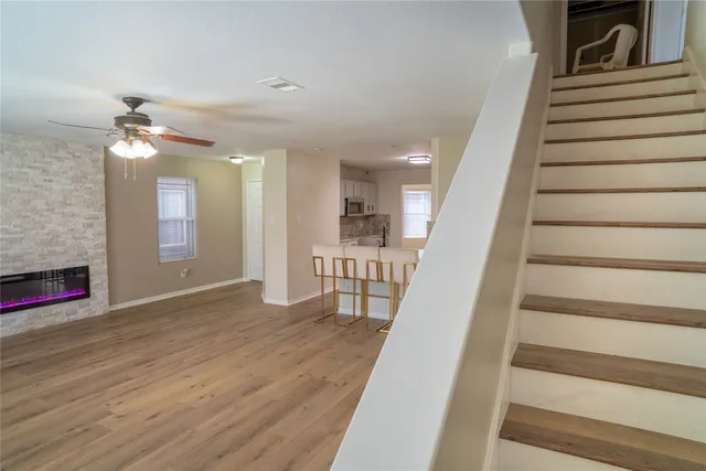 a view of an entryway with wooden floor and livingroom view
