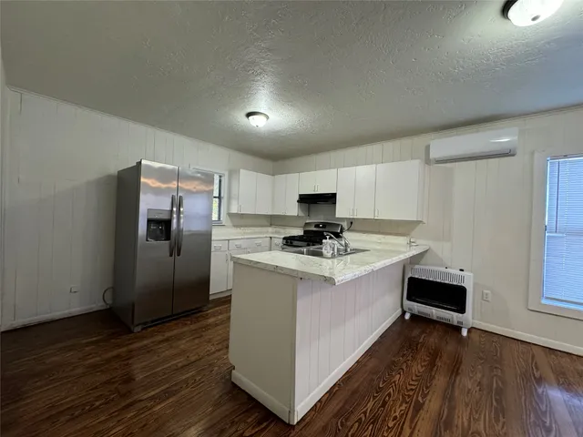 a view of kitchen with sink and refrigerator