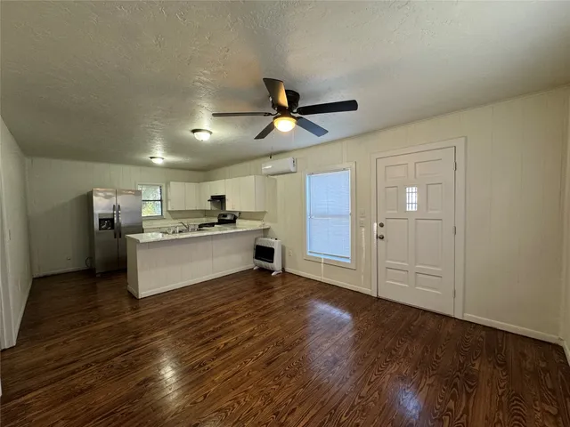 a view of kitchen with granite countertop cabinets and refrigerator