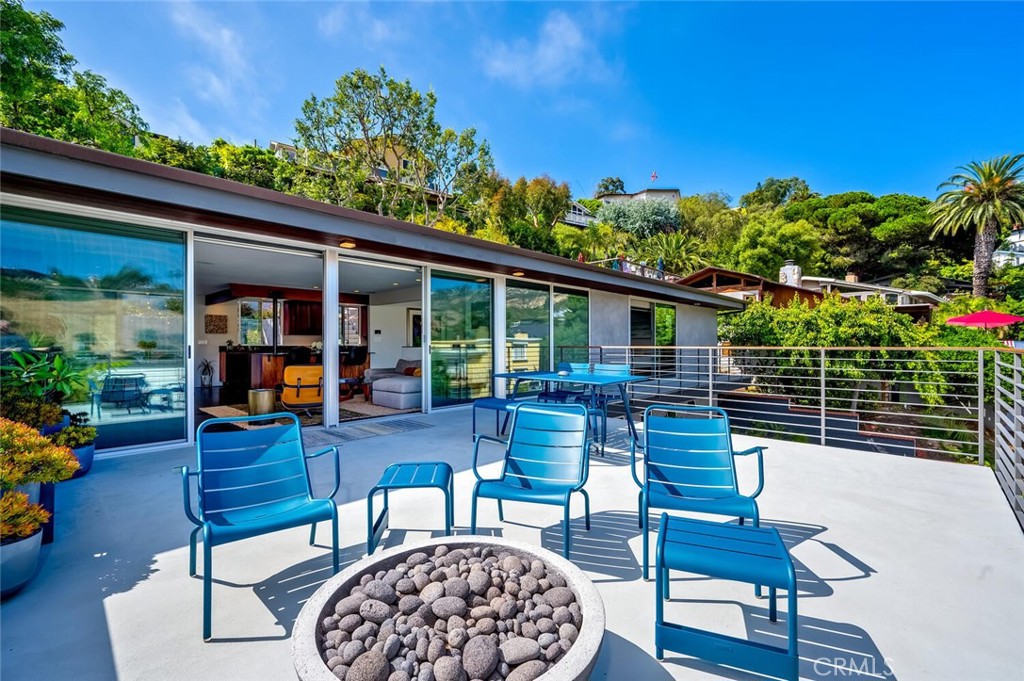 1340 Cerritos Drive Laguna Beach, CA 92651 - Photo 40 of 46 a view of a patio with couches table and chairs under an umbrella with wooden floor