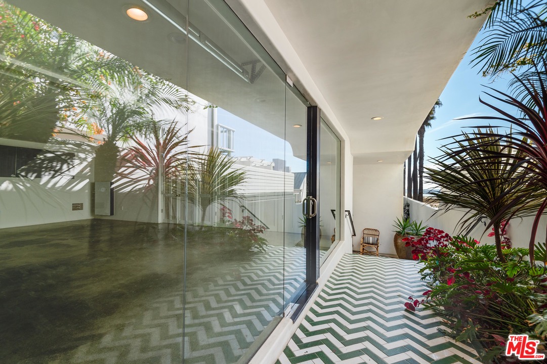 30826 Broad Beach Road Malibu, CA 90265 - Photo 11 of 23 a porch with a potted plant and floor to ceiling window