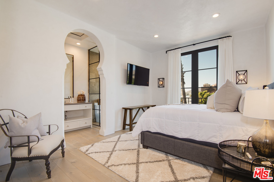 30826 Broad Beach Road Malibu, CA 90265 - Photo 18 of 23 a bedroom with a bed and a chandelier