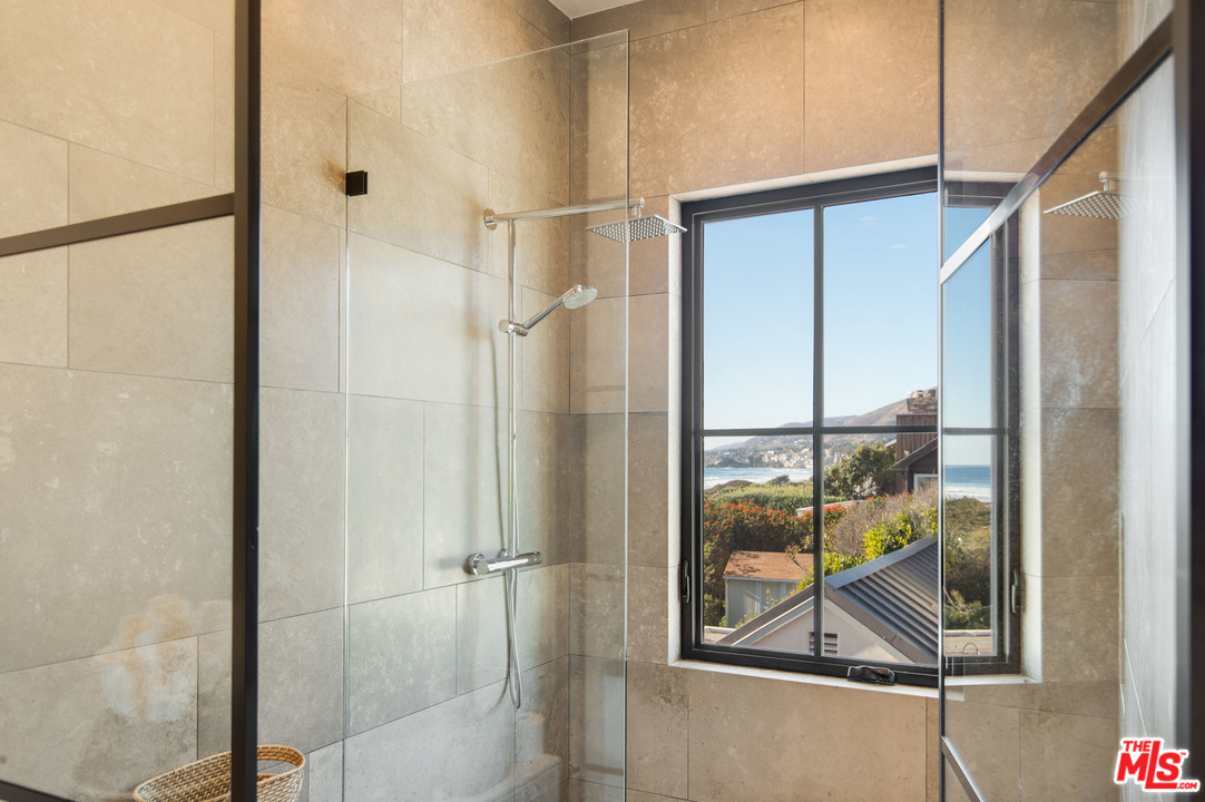 30826 Broad Beach Road Malibu, CA 90265 - Photo 21 of 23 a bathroom with a glass shower door and mirror
