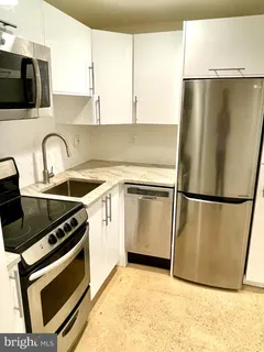 a kitchen with a refrigerator a stove and a sink