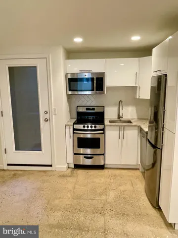 a kitchen with stainless steel appliances a refrigerator stove and microwave