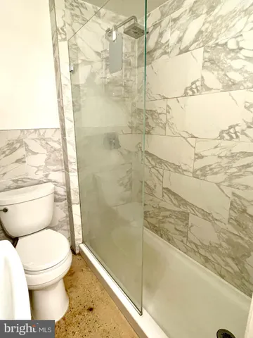 a bathroom with a toilet and a shower