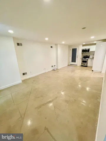 a view of empty room with kitchen