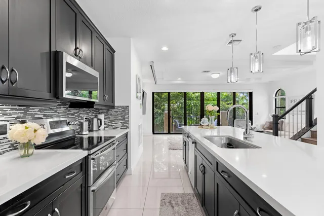 a kitchen with stainless steel appliances a sink a stove and a wooden floors