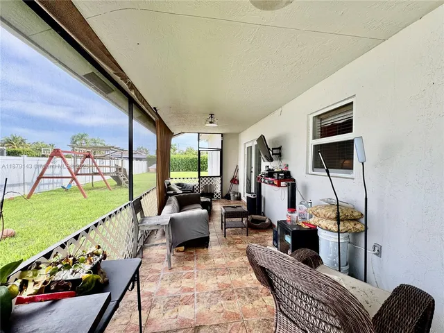 a living room with furniture and a floor to ceiling window