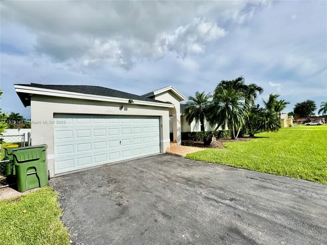 a view of a house with a yard and garage