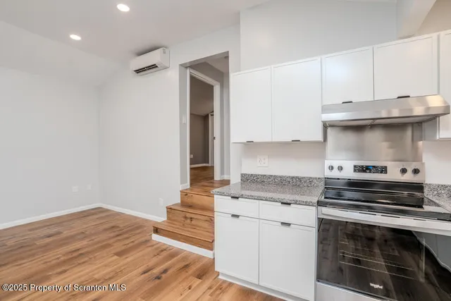 a kitchen with granite countertop a stove and a sink