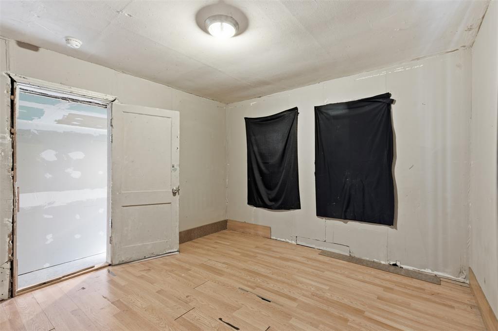 1703 Navaro Street Dallas, TX 75208 - Photo 21 of 28 an empty room with wooden floor and bathroom