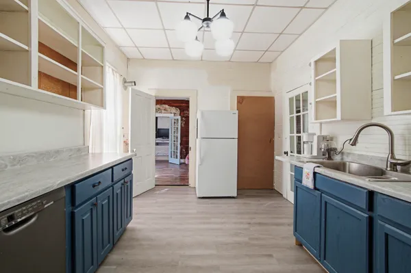 a kitchen with stainless steel appliances granite countertop a refrigerator a sink dishwasher a stove and a dining table with wooden floor