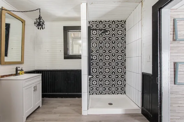 a bathroom with a shower a sink and a mirror